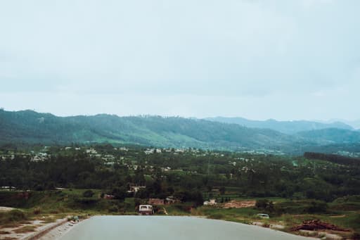 Scenic road leading towards Nirvaana Hills Aravalli green landscape